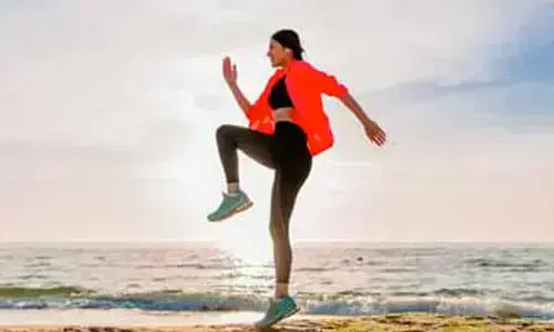 Woman doing warmup exercises across the beach